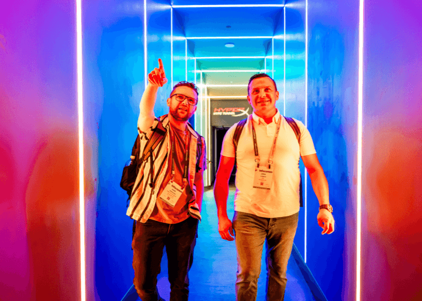 two men walkign through a colored lit hallway